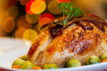 close up of a roasted turkey butterfly on a plate with sprouts 