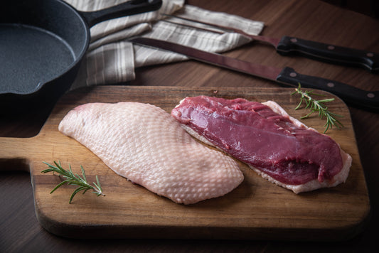 raw duck breast on wooden chopping board 